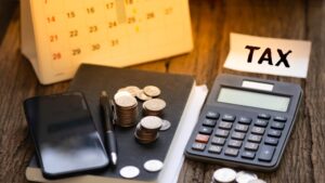 Calculator on documents with coins and calendar