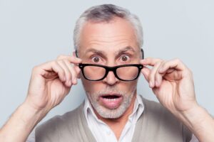 surprised old man taking off and on his glasses